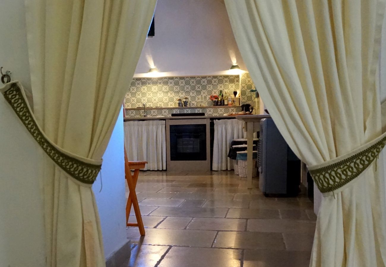 A kitchen with a tiled backsplash, a stove, and a sink.