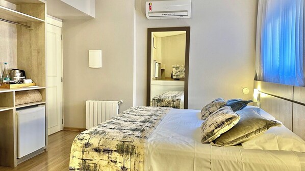A hotel room with a bed, a wardrobe, a radiator, and a mirror. - Hotel Glamour da Serra (Gramado)