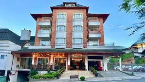 A hotel with a brick facade, multiple balconies, and a well-lit entrance. - Hotel Glamour da Serra (Gramado)