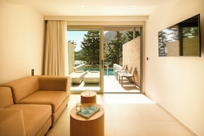 A modern living room with a sofa, a coffee table, and a sliding glass door leading to an outdoor seating area.