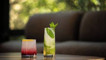 Two drinks on a table with a blurred outdoor background.