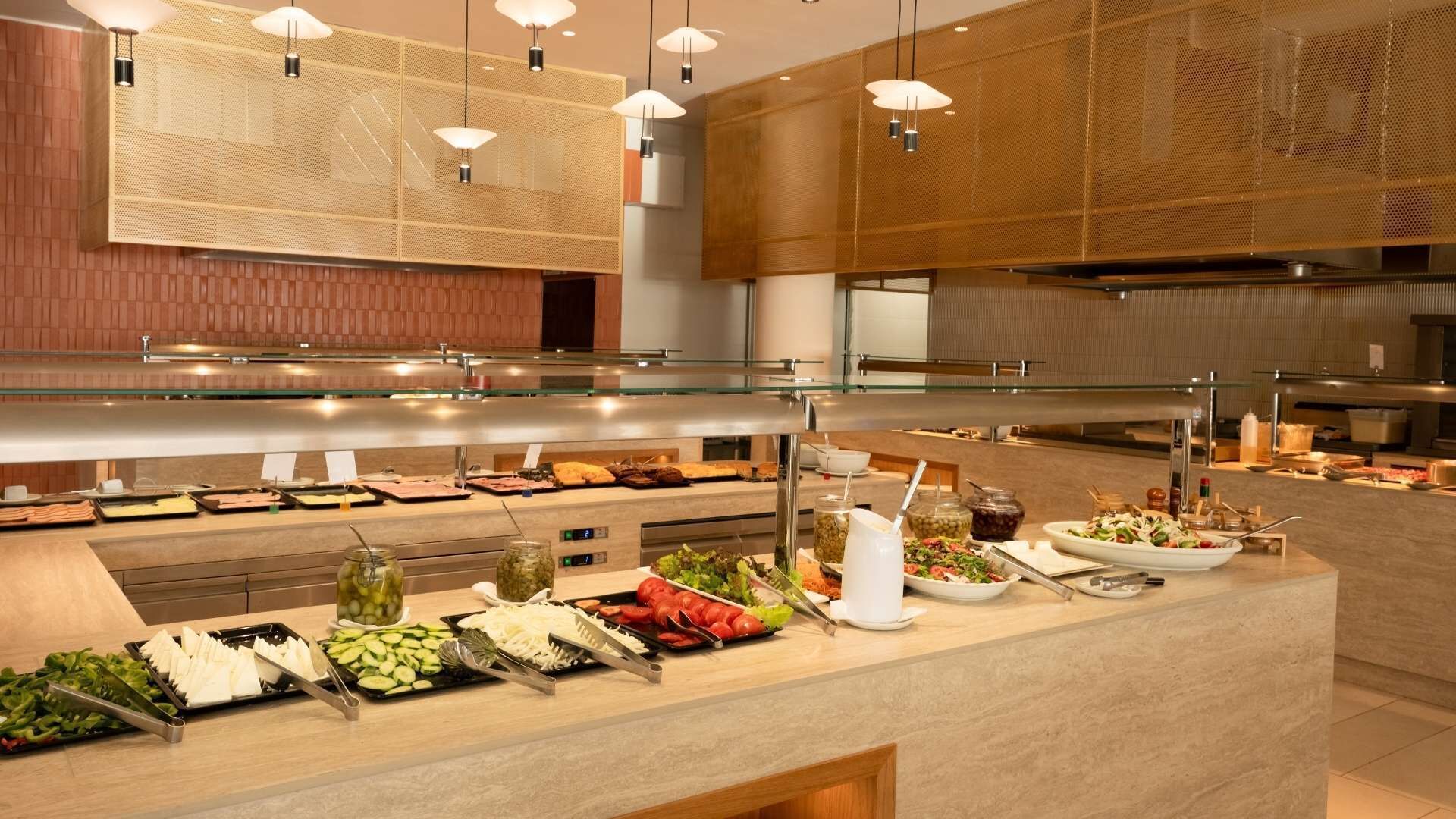 Ein Buffet mit verschiedenen Speisen, einer Glasvitrine und modernen Leuchten.