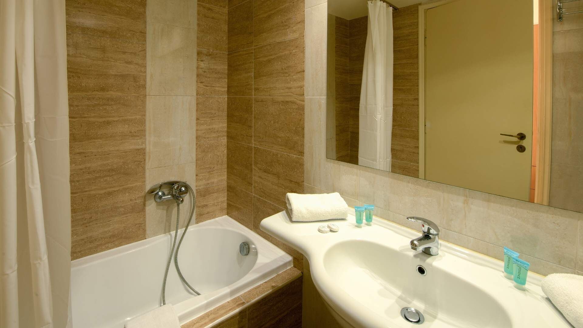 A bathroom with a bathtub, a sink, and a mirror.