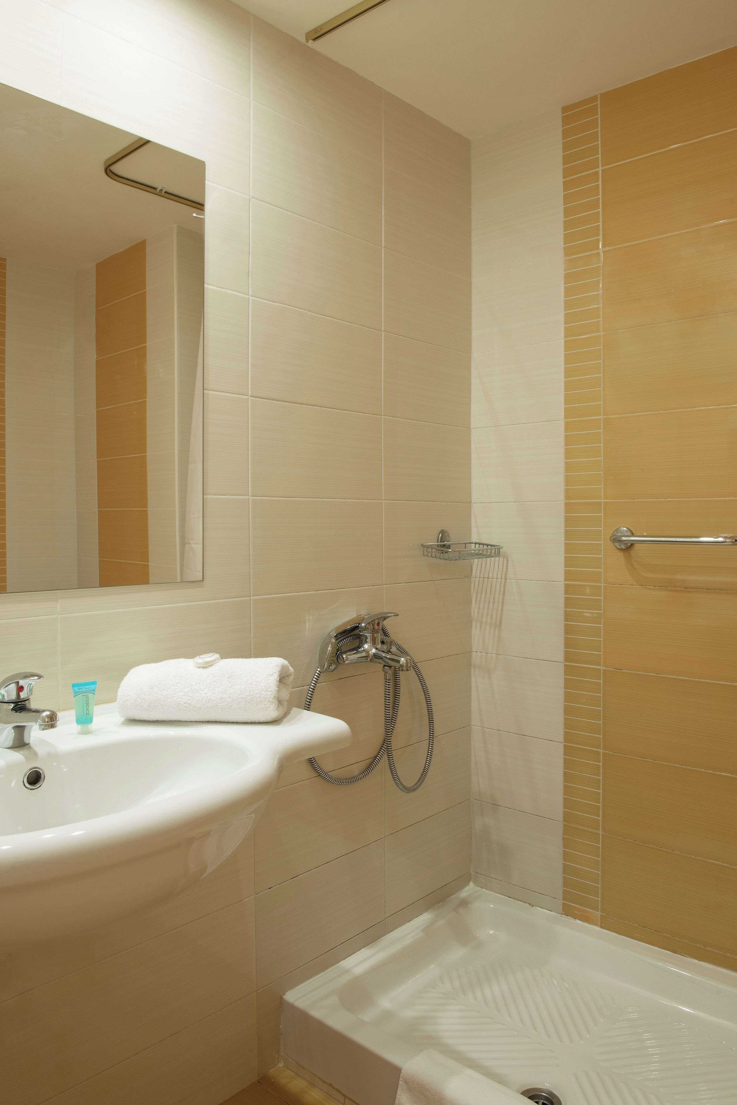 Un baño con lavamanos, espejo y ducha.