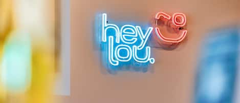 En neonskilte med teksten 'hey you'.