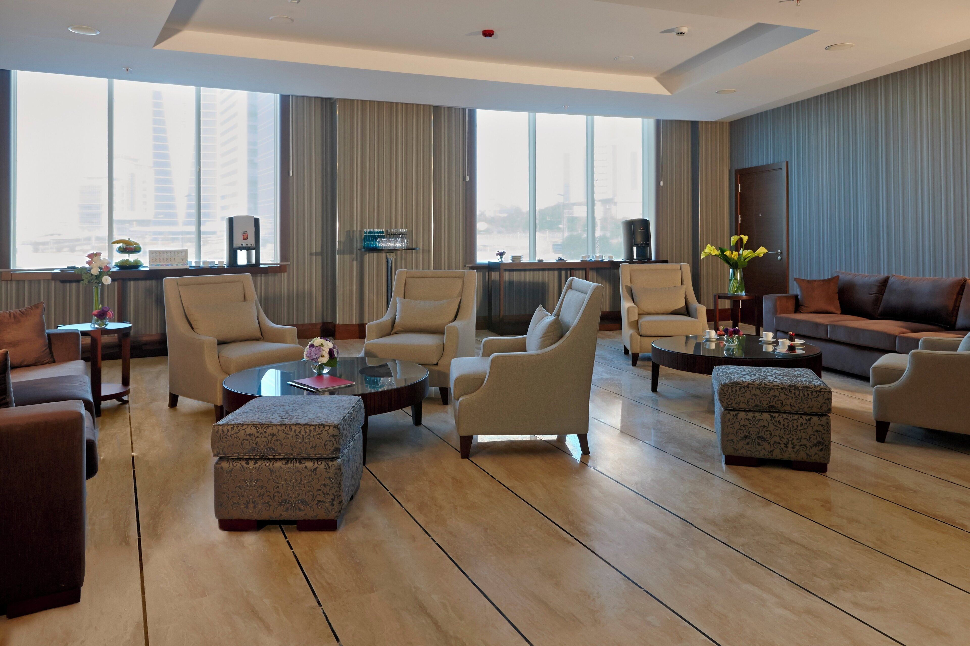 A modern living room with a large window, multiple seating options, and a coffee table.