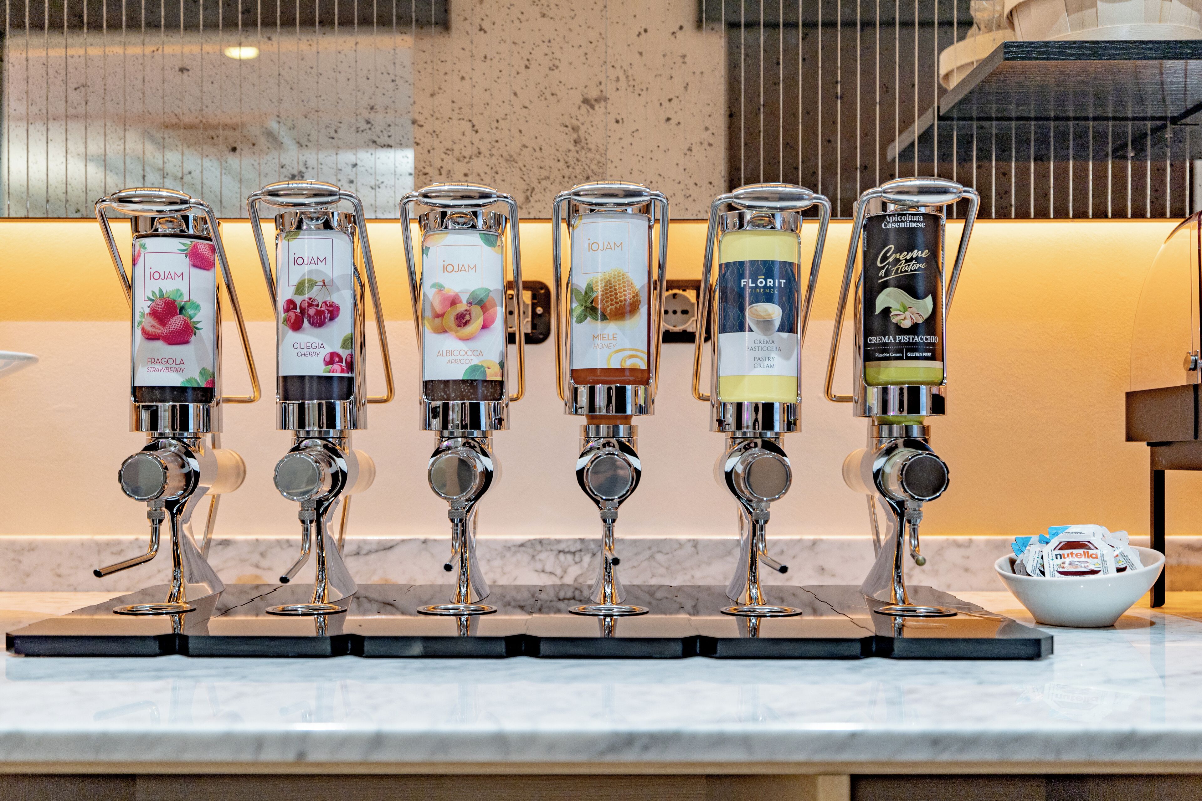 A row of beverage dispensers with labels indicating different flavors.