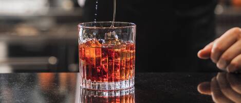 A bartender pouring a drink into a glass.