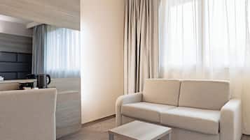 A modern living room with a sofa, a coffee table, and a kitchen area in the background.