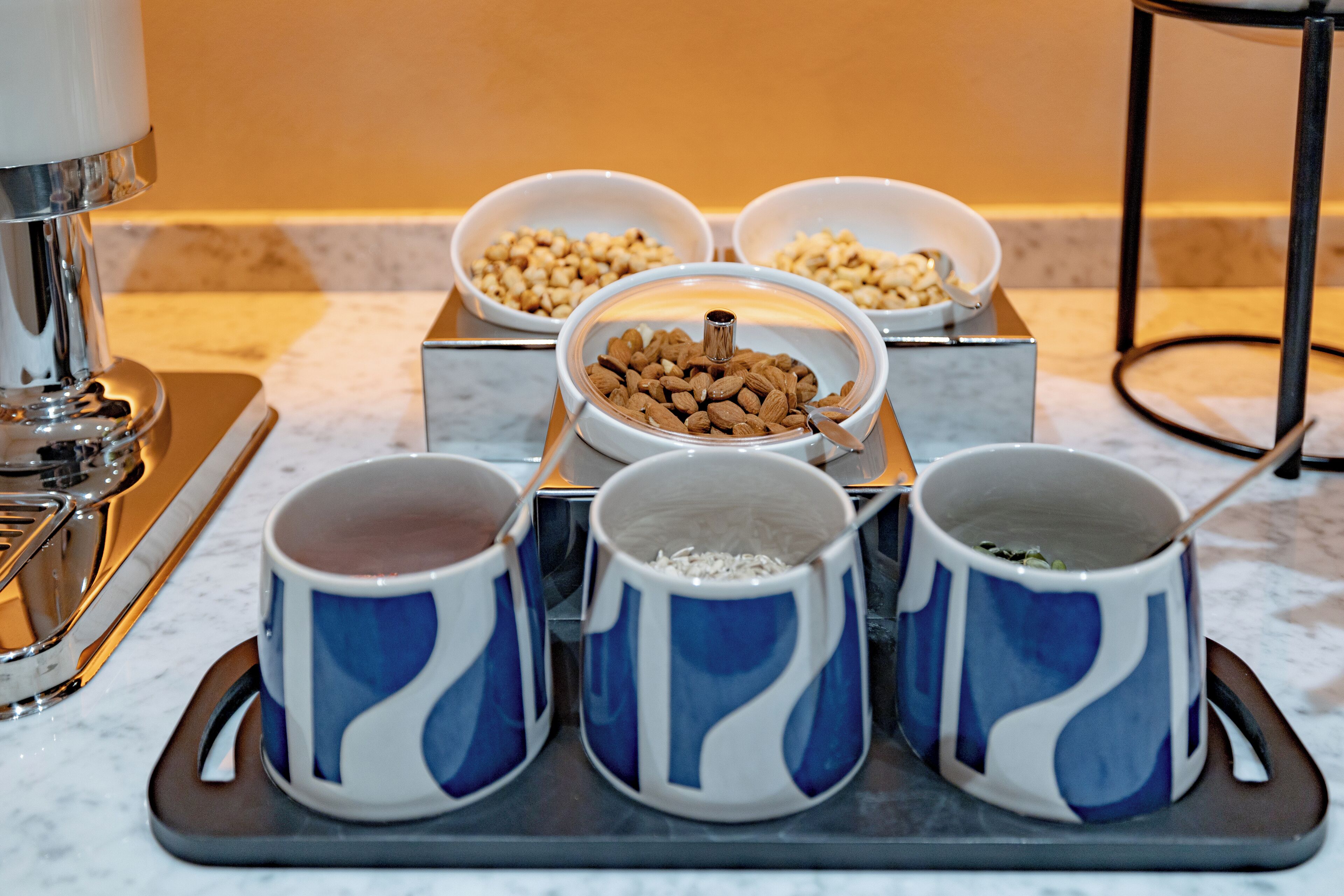 A tray with four blue and white mugs and three bowls containing different food items.