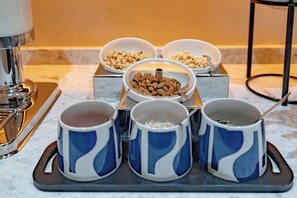 Una bandeja con cuatro tazas azules y blancas y tres cuencos que contienen distintos alimentos.