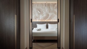 A modern hotel room with a large bed, a marble headboard, and a wooden floor. - Just Hotel Saronno (Saronno)
