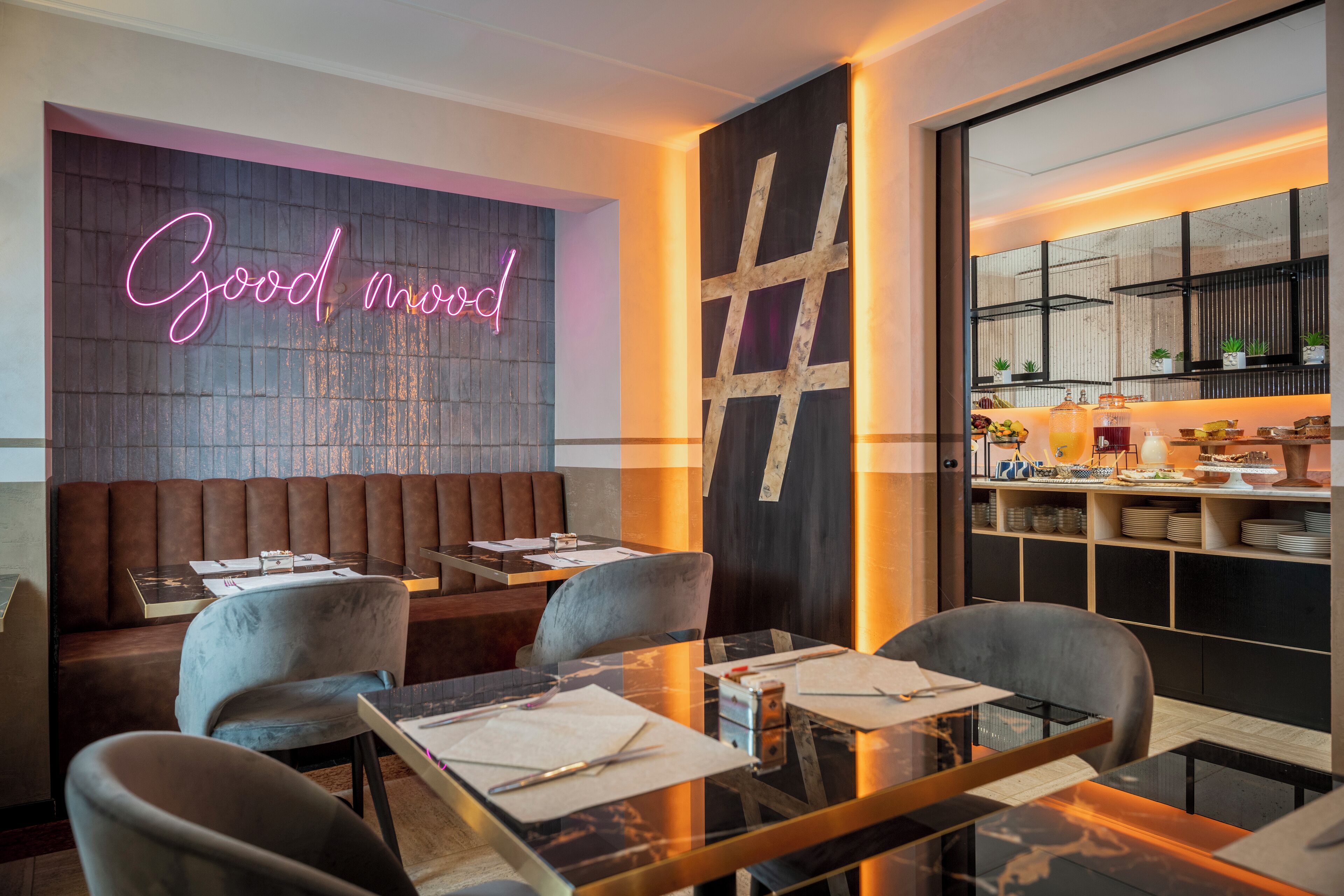 A modern restaurant with a neon sign, wooden panel wall, and a bar area with shelves.