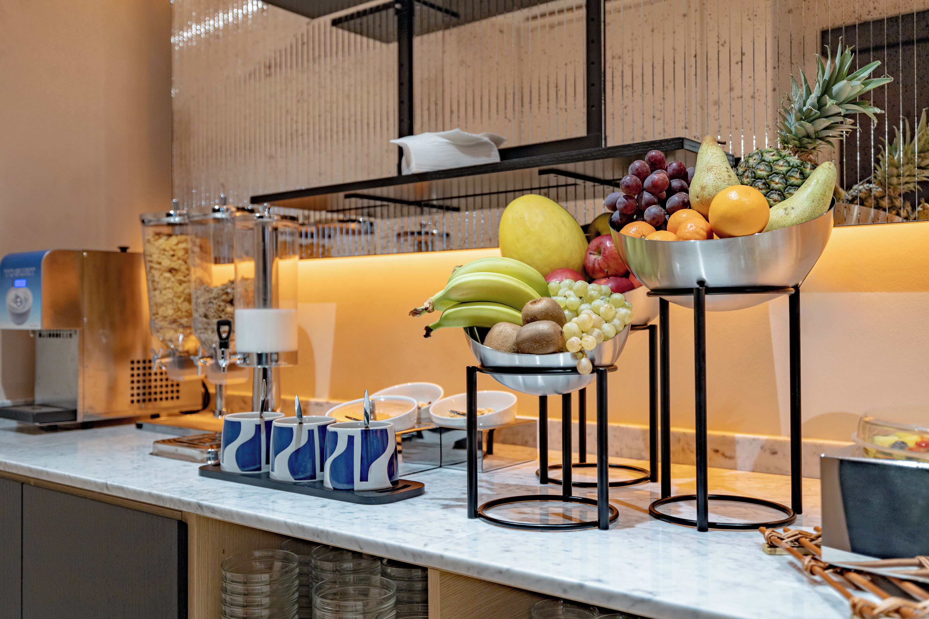 Een ontbijtbuffet met diverse soorten fruit en drankjes.