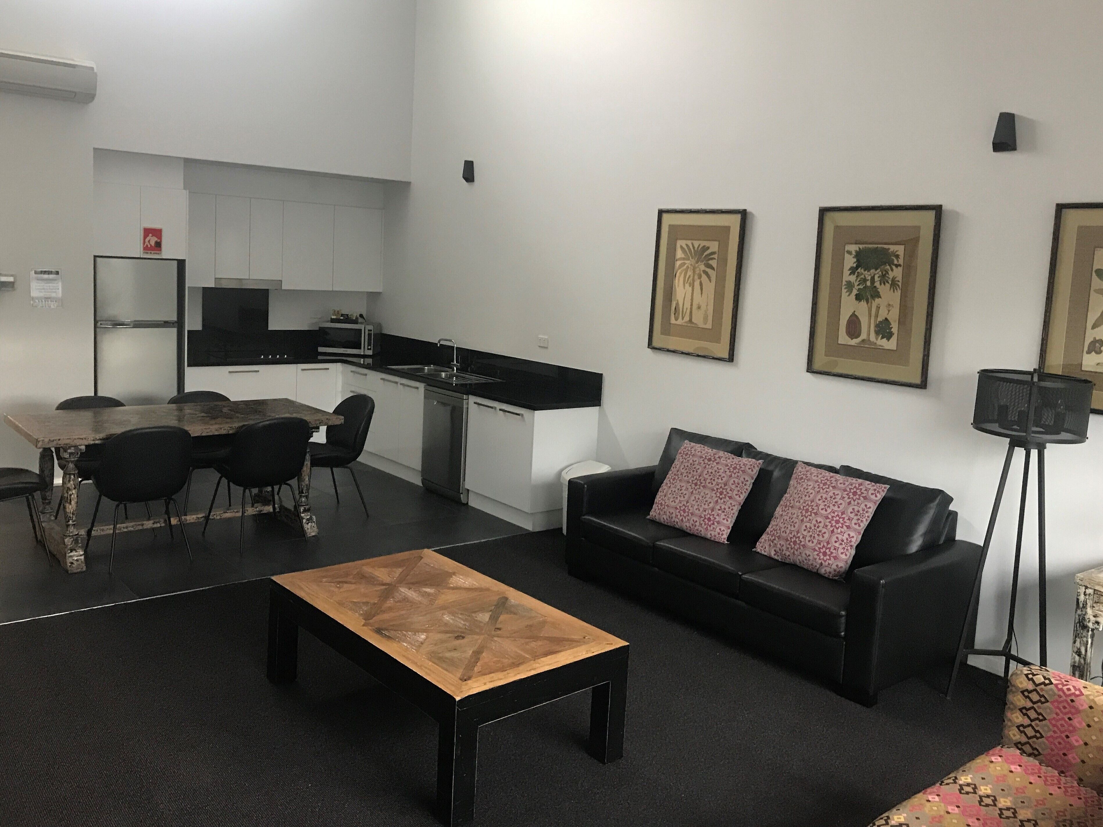 A compact living space with a dining area, a sofa, a coffee table, and a kitchenette.