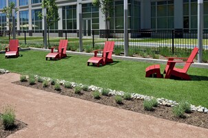 Terras met rode stoelen en een geplaveid pad.