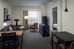 Une chambre d’hôtel équipée d’un bureau, d’une chaise, d’un canapé, d’une télévision et d’un lit.