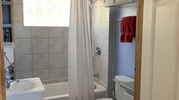 A bathroom with a bathtub, toilet, and sink.
