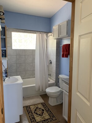 A bathroom with a bathtub, toilet, and sink.