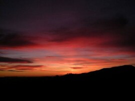 Un atardecer sobre un paisaje montañoso.