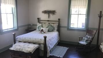 A bedroom with a wooden bed, a rocking chair, and a dresser.