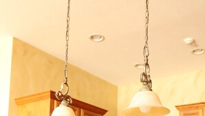 A kitchen with wooden cabinets, stainless steel appliances, granite countertops, and pendant lighting.