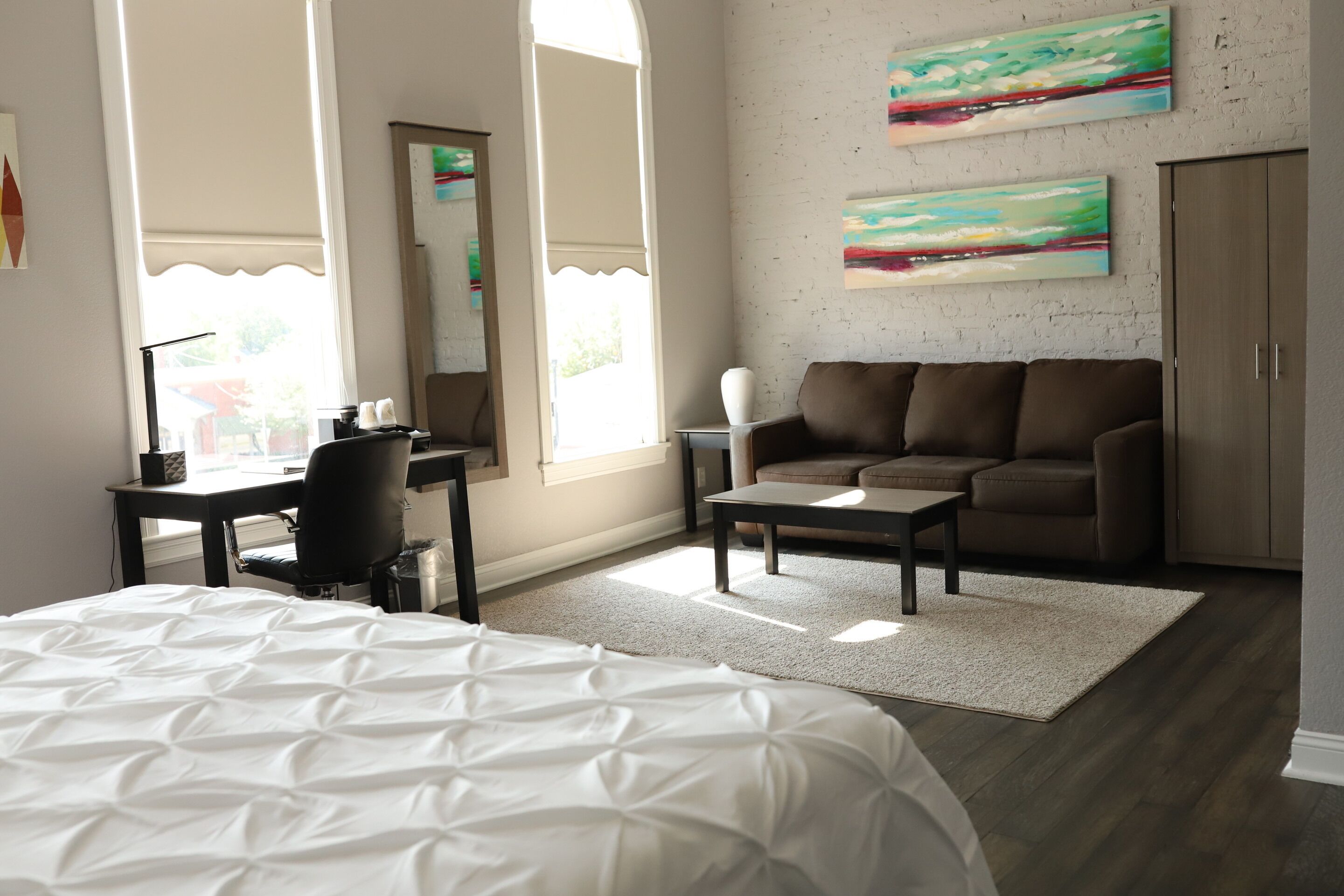 Une chambre moderne avec un grand lit, un bureau, un canapé et une armoire.