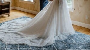 A room with wooden walls, large arched windows, and a blue rug.