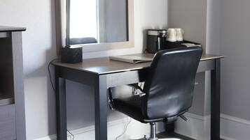 A modern office space with a desk, chair, and a large mirror.