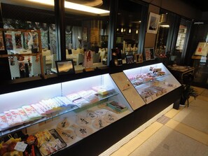 A display case with various items, including folded papers and small packages, in a well-lit indoor setting. - Hotel Kikunoya (Hatsukaichi)