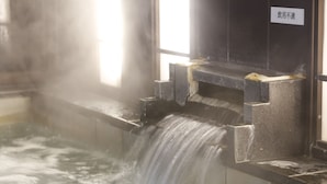 A hot spring with a waterfall feature, a sign indicating no alcohol use, and a window allowing natural light. - Hotel Kikunoya (Hatsukaichi)
