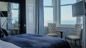 A hotel room with a bed, a chair, a small table, and a TV. - Bayswell Park Hotel (Dunbar)