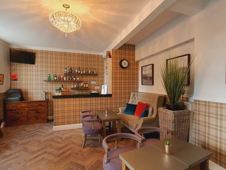 Een gezellige kamer met een bar, een bank en een eettafel.
