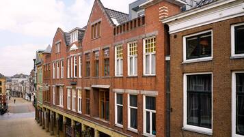 A row of red brick buildings with white window frames and a covered walkway.
