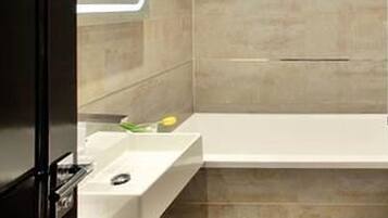 Een moderne badkamer met een douchecabine van glas, een witte wastafel en een toilet.