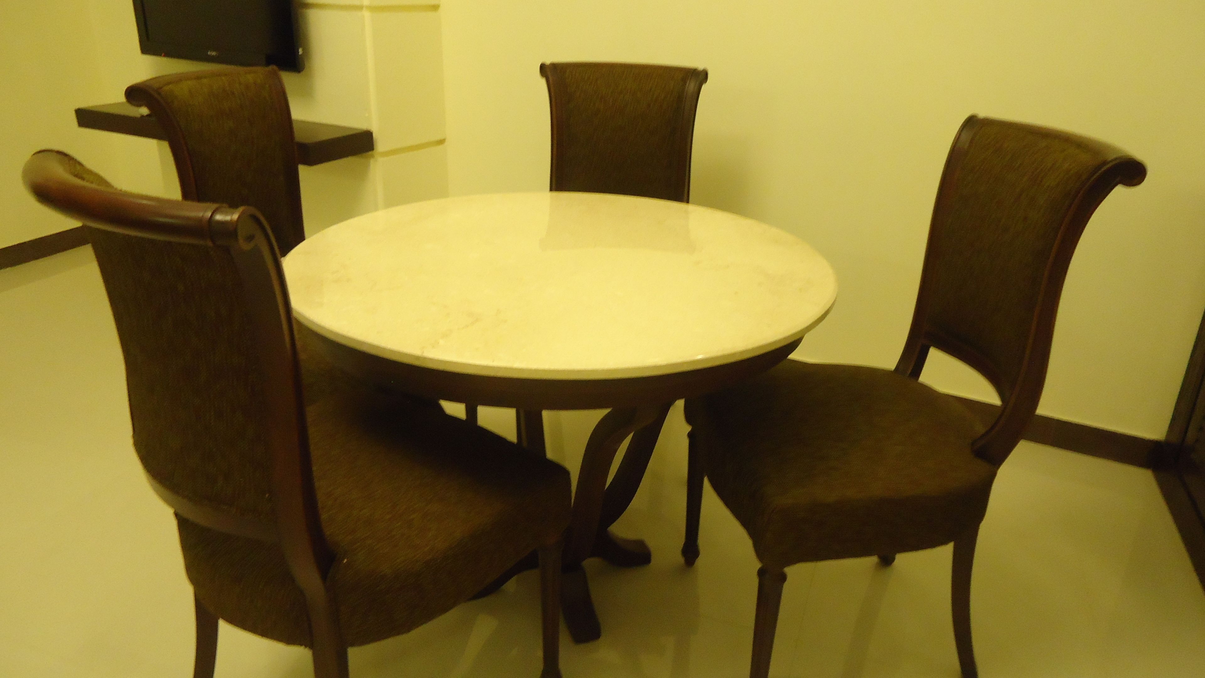 A round table with four chairs around it.