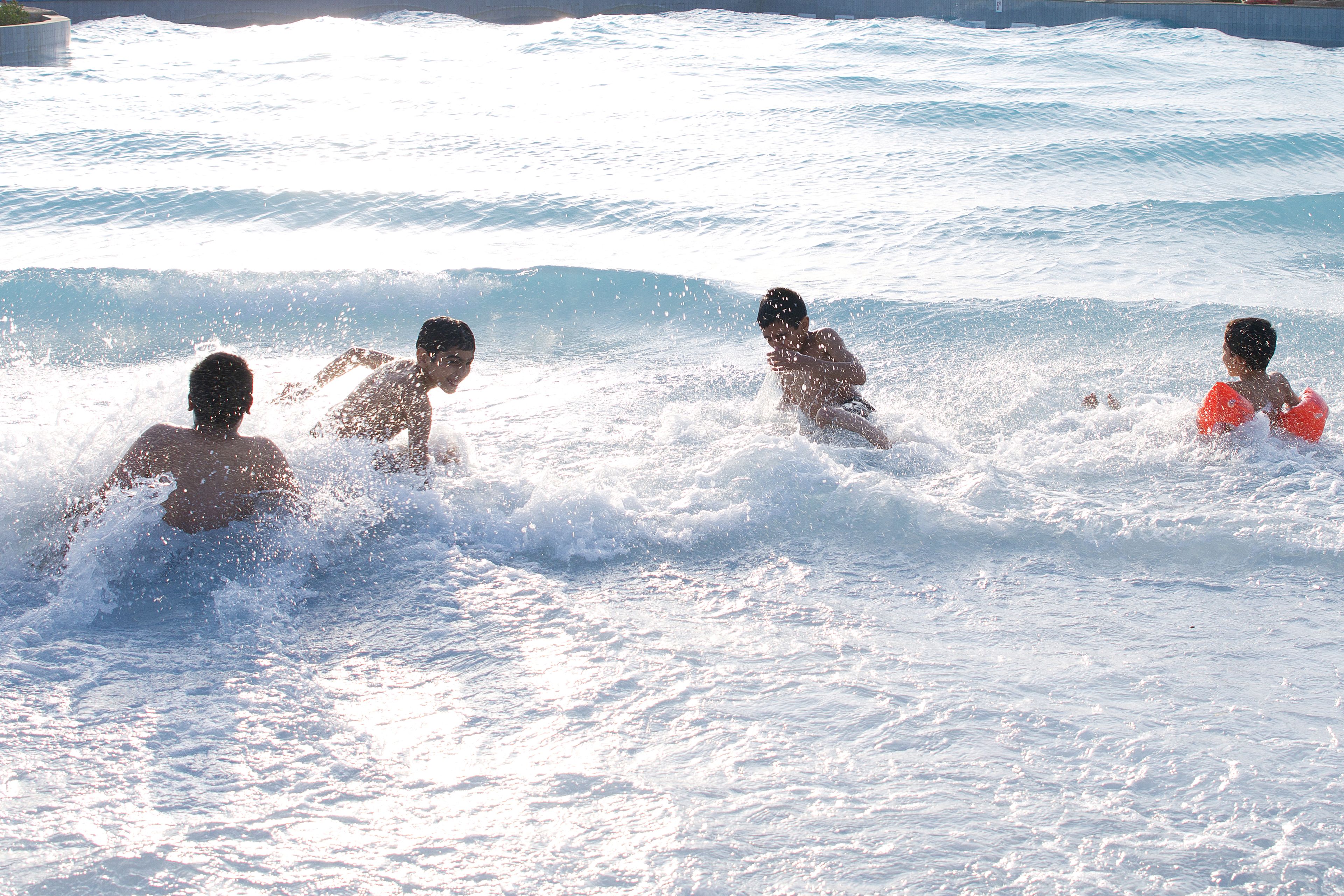Una piscina con cuatro personas jugando en el agua.