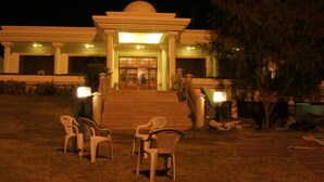 A building with a central entrance, steps leading up to it, and a few chairs in front. - Dreamworld Resort, Hotel & Golf Course (Karachi)