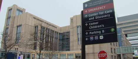 Un cartel con indicaciones hacia diferentes servicios, incluyendo el University of Chicago Medicine, Emergencias, Centro para el Cuidado y el Descubrimiento, Comer Children’s y el estacionamiento B.