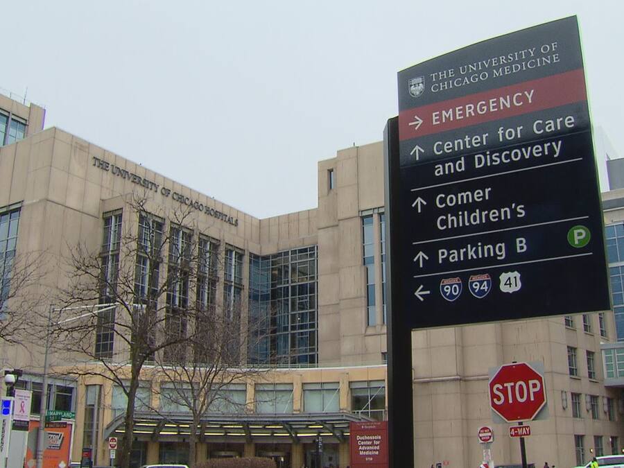 Un cartel con indicaciones hacia diferentes servicios, incluyendo el University of Chicago Medicine, Emergencias, Centro para el Cuidado y el Descubrimiento, Comer Children’s y el estacionamiento B.