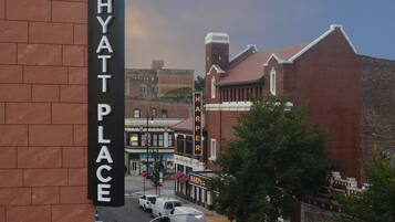 A street view with a brick building labeled "HYATT PLACE" and a sign for "HARPER'S LAUNDRY."