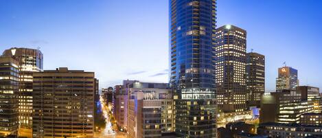A cityscape with modern high-rise buildings, a well-lit street, and a clear sky.