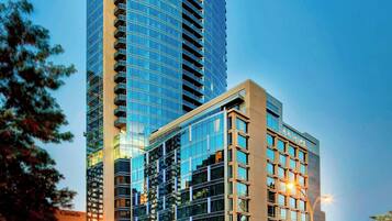 A high-rise hotel with a curved facade, multiple balconies, and a prominent entrance.