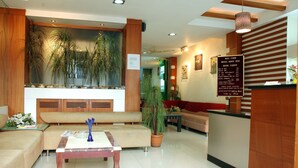 A hotel lobby with a reception desk, seating area, and a large wall-mounted plant. - Hotel Imperial Classic (Hyderabad)