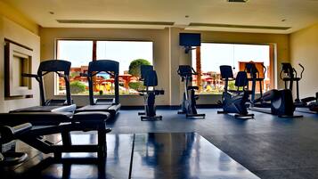 Un gimnasio con cintas de correr, elípticas y bicicletas estáticas.