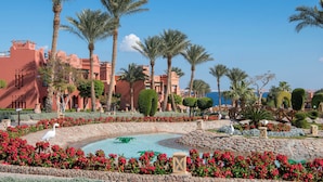 A resort with palm trees, a swimming pool, and a view of the sea. - Charmillion Sea Life Resort (Sharm El Sheikh)