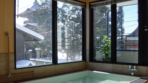 A large, rectangular glass bathtub in a room with large windows. - Minshuku Kuwataniya (Takayama)