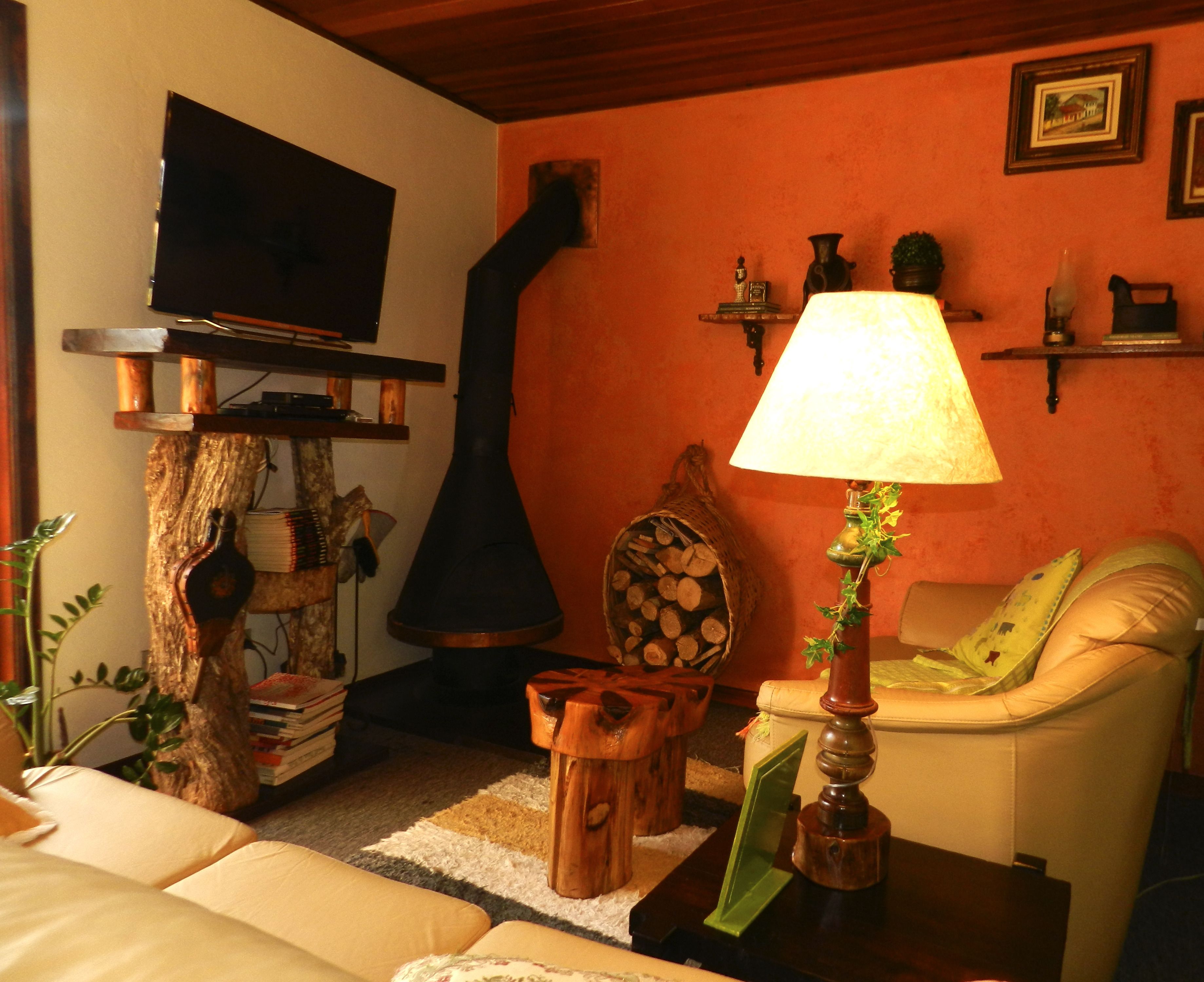 Ein gemütliches Wohnzimmer mit Fernseher, Kamin, Lampe und Sofa.