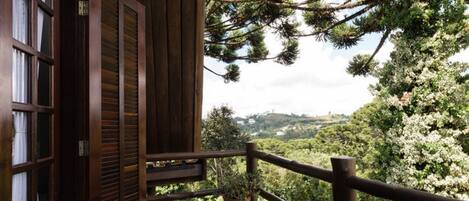 Un balcón de madera con vistas a un paisaje exuberante.