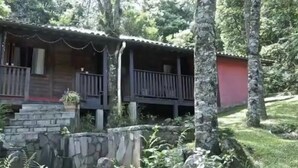 Eine rustikale Holzhütte mit Stein Fundament und einem Balkon.